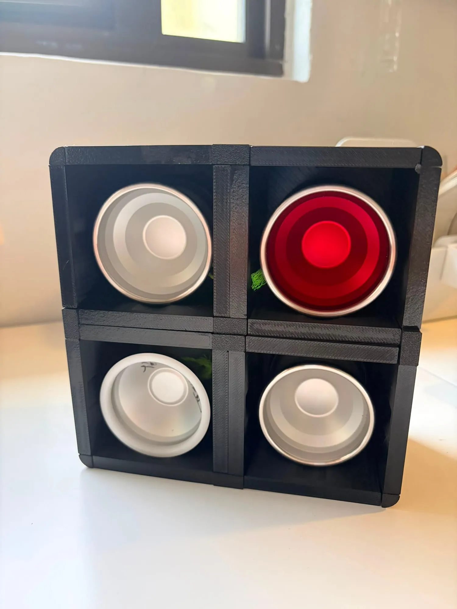 Four black ThrowGRID display cubes in a 2x2 grid, each holding a yo-yo