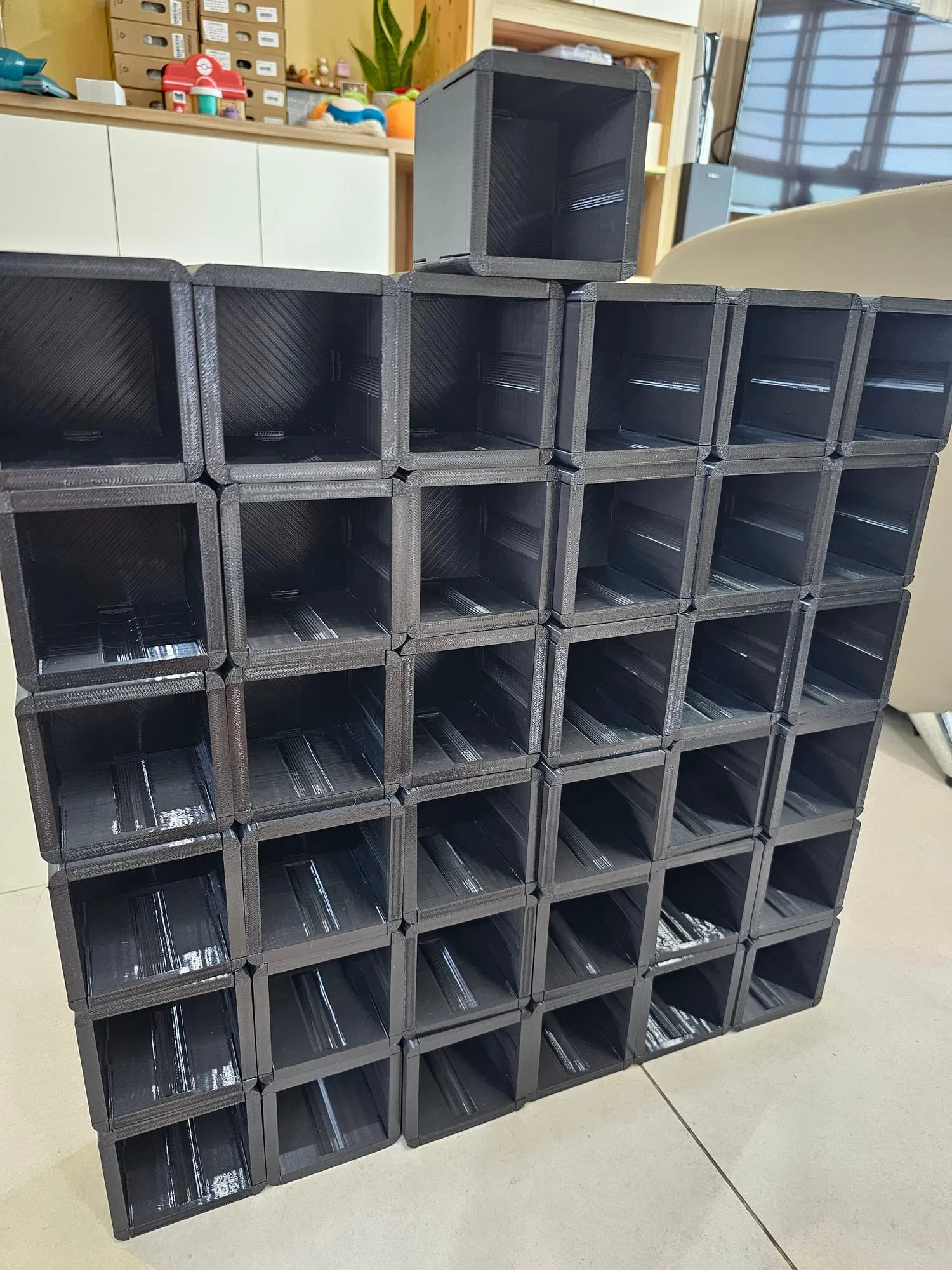 A large batch of black ThrowGRID cubes laid out after printing